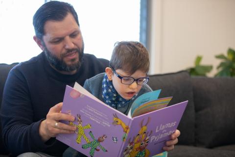 Diagnosis Day family - father and child reading together.