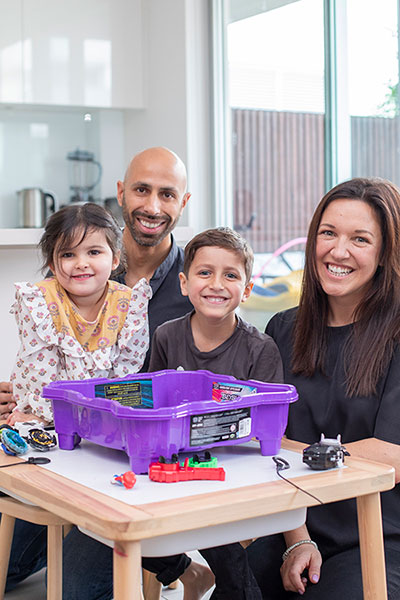 Family posed around children's toy.